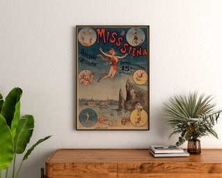 Vintage circus poster Miss Stena—Descent of Absalon—framed above a wooden dresser between plants.