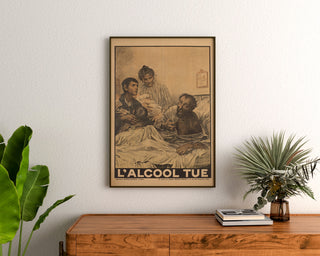 Historic poster – L’Alcool tue – Eugène Burnand, framed above a wooden sideboard, between plants.