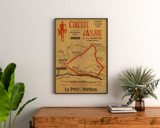 Vintage Circuit d’Anjou poster, walking, framed above a wooden chest of drawers, between plants.