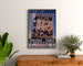 Vintage poster Épicerie Lefèvre, coffees and chocolates, framed above a wooden dresser, between plants.
