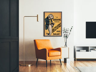 Vintage poster La Sardine française, Béziers, framed in a living room with an orange armchair and a floor lamp.