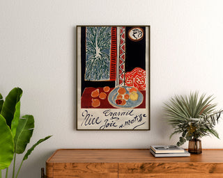 Vintage Nice poster, Travail et Joie, framed above a wooden dresser between plants.