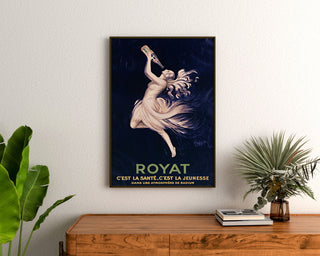 Vintage Royat poster, Santé et Jeunesse, framed above a wooden dresser between plants.