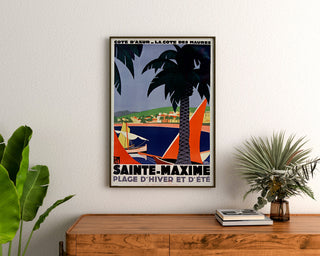 Vintage Sainte-Maxime poster, Côte des Maures, framed above a wooden dresser, between plants.