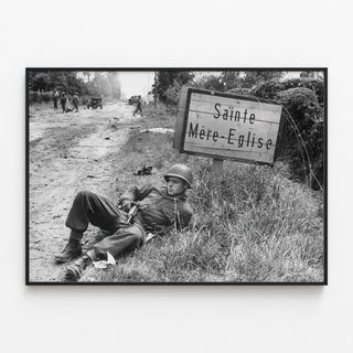 American paratrooper resting near Sainte-Mère-Église | Art print of historic photo — framed artwork on a wall